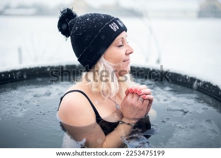 Girl is hardening by cold water during snowing