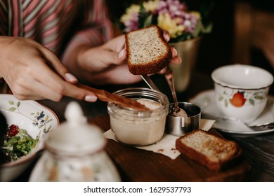 The girl has a big plan to smear the toast with pate - Shutterstock ID 1629537793