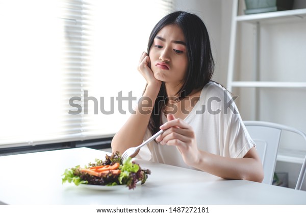 その女の子は野菜を食べるとつまらない表情をする 彼女は美味しい食べ物を食べたい 食事 清潔な食べ物 健康的な食べ物のコンセプト の写真素材 今すぐ編集
