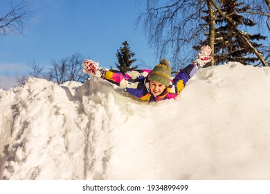 The Girl Has Fun On A Winter Walk, Riding On A Snow Slide. 