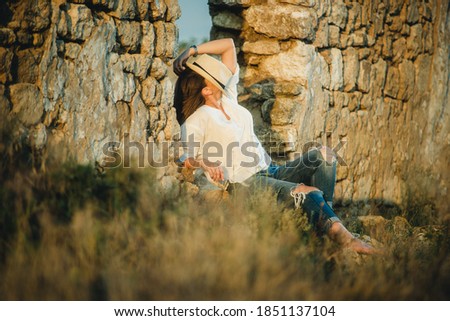 girl in a hat near a stone wall
