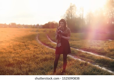 A girl in a hat on a walk in the park. A girl with a basket walks in autumn. Girl is walking along the road at sunset. - Shutterstock ID 1525090838