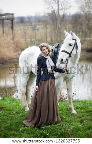 girl in a hat with a white horse on nature