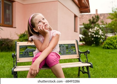 Girl Having Big Problems - Sitting On Bench In Backyard With Family House Behind