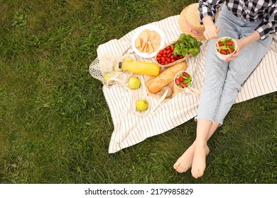 Girl Having Picnic On Green Grass In Park, Above View