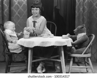 Girl Having Tea Party With Doll And Bear