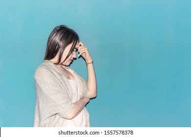 Girl with a headache leaning her hand to her head is trying to alleviate the pain in her head. - Shutterstock ID 1557578378