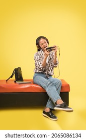 girl headphones playing game using a mobile phone - Shutterstock ID 2065086134