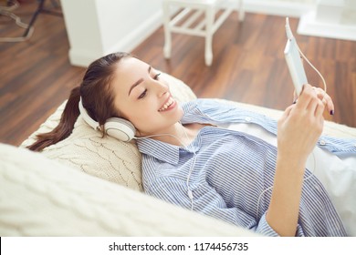 Girl in headphones smiling listening to music. - Shutterstock ID 1174456735
