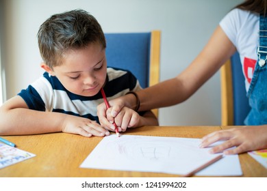Girl helping her brother to draw