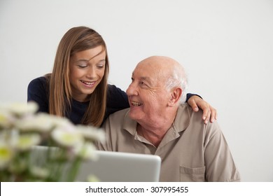 Girl Helping To Her Grandfather With The Computer