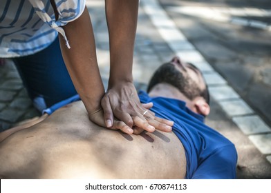 girl helping an unconscious guy with cpr and cardiac massage