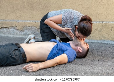 Girl Helping An Unconscious Guy With Mouth To Mouth Resuscitation And Cpr