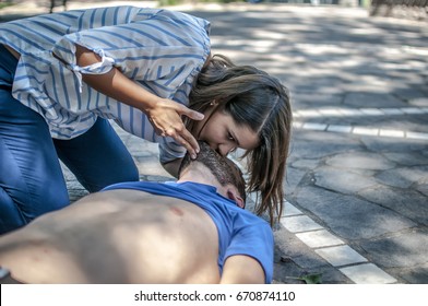 Girl Helping An Unconscious Guy With Mouth To Mouth Resuscitation And Cpr