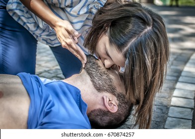 girl helping an unconscious guy with mouth to mouth resuscitation and cpr