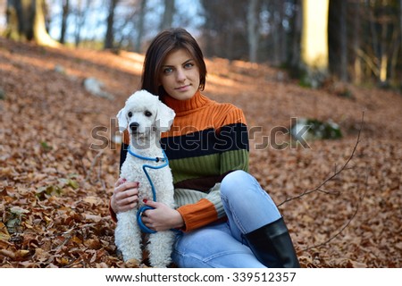 Girl with her dog in colorful autumn forest in the mountains