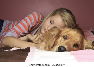 Girl and her dog sleeping together on a bedroom
