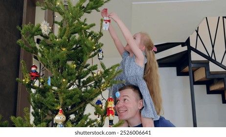 Girl and her father share joy and love while decorating a christmas tree in a cozy, festive home filled with lights and decorations. New Year's Eve with family - Powered by Shutterstock