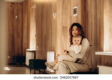 Girl with her mother settled down in the waiting area in the hospital corridor - Powered by Shutterstock