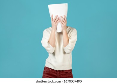 The girl hid her face behind a contract or other document. The office employee is tired and wants nothing but relaxation