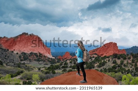 Girl hiker relaxing on top of the mountains looking at beautiful scenery. Garden of the Gods, Colorado Springs, Colorado,  USA.