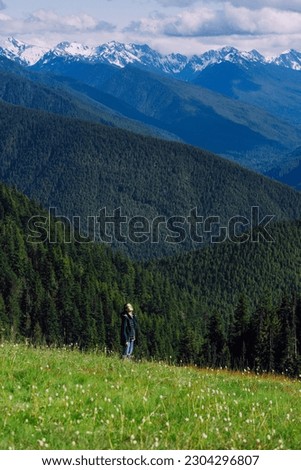Girl hiker is soaking in the sun in flower fields in Olympic NP