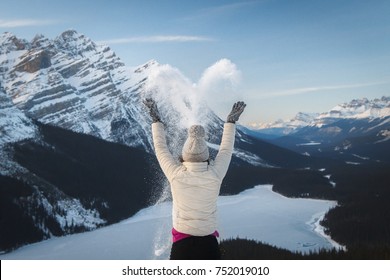 Girl Hiker Spreading Snow In Heart Shape At Bow Summit. View Over Peyto Lake, Banff, Canadian Rockies, Alberta, Canada. Cold Freezing Winter Activities. Outdoor Lifestyle Happiness Concept. 