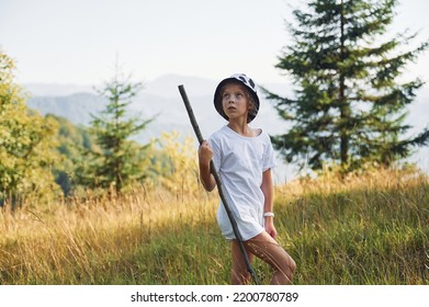 Girl Is Hiking In The Carpathian Mountains In Ukraine. Holding Wooden Stick In Hand.