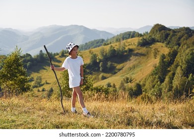 Girl Is Hiking In The Carpathian Mountains In Ukraine. Holding Wooden Stick In Hand.