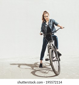 Girl Hipster Standing With Black Bike Near Wall. Outdoor Lifestyle Portrait