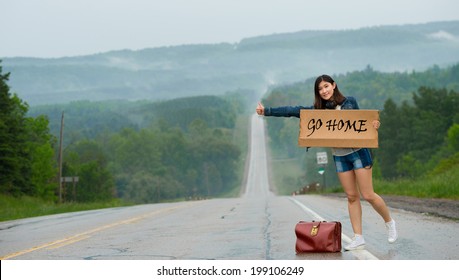  girl hitchhiking holds up a  sign 