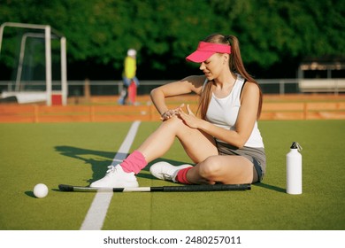 girl hockey player plays field hockey on a sunny day, a hockey player was injured in a game of field hockey, sports injuries - Powered by Shutterstock