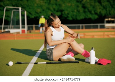 girl hockey player plays field hockey on a sunny day, a hockey player was injured in a game of field hockey, sports injuries - Powered by Shutterstock