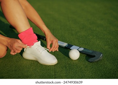 girl hockey player tying sneakers on the field hockey field, concept of playing field hockey, women's sport - Powered by Shutterstock