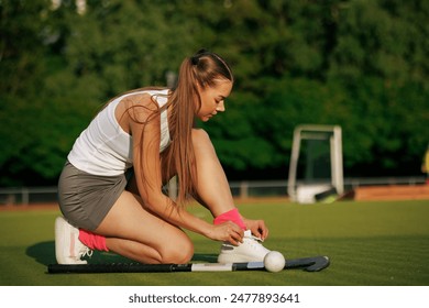 girl hockey player tying sneakers on the field hockey field, concept of playing field hockey, women's sport - Powered by Shutterstock