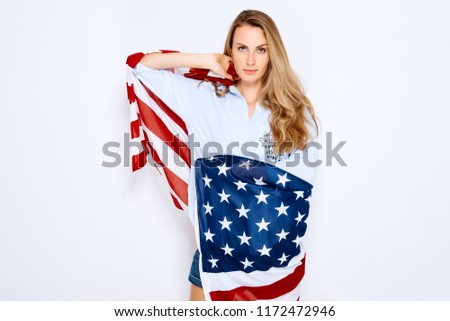 Girl holding an American flag on a white background. The concept of migration, national holidays and of national holidays and Independence Day of Independence of America July 4