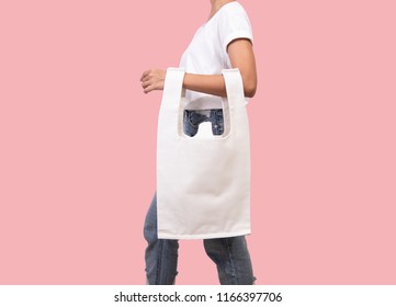 Girl Is Holding Bag Canvas Fabric For Mockup Blank Template Isolated On Pink Background. 