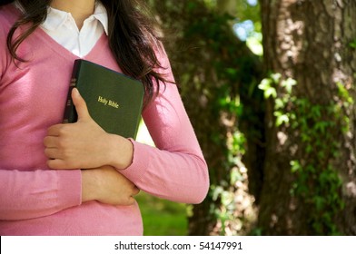 Girl Holding A Bible In Nature