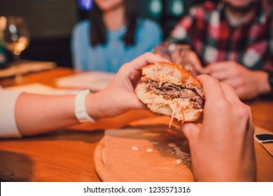 Girl holding a bitten off a piece burger in one hand. Girl with delicious tasty fast food cheeseburger. The concept of fast food. Tasty unhealthy Burger sandwich in hands,