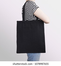 Girl is holding black cotton eco tote bag, design mockup.