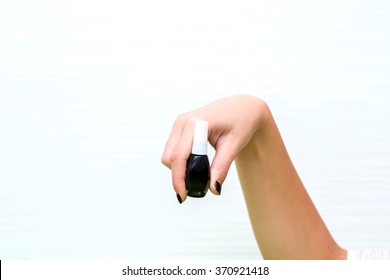 girl holding a black nail polish on a white background - Shutterstock ID 370921418