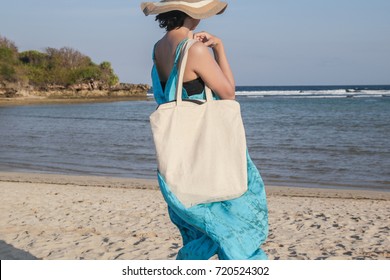 Girl Is Holding Blank Canvas Tote Bag On Beach, Woman Travelling Back View