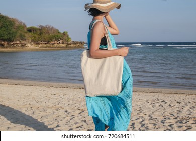 Girl Is Holding Blank Canvas Tote Bag On Beach, Woman Travelling Back View