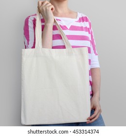 Girl is holding blank cotton eco tote bag, design mockup.