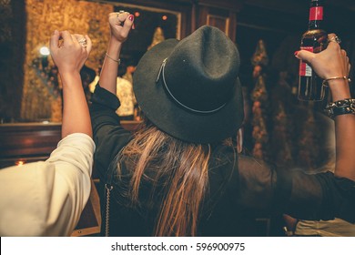 A Girl Is Holding A Bottle Of Beer At A Party