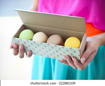 Girl holding box with colorful French macaroons in her hands - Powered by Shutterstock