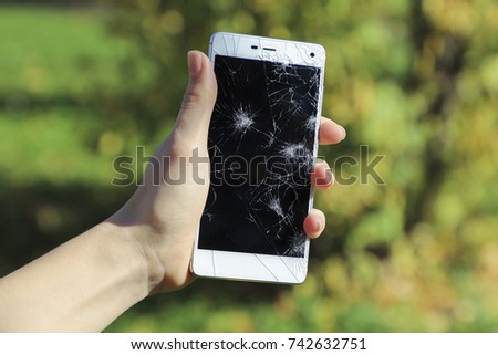 Girl holding a broken smart phone.
