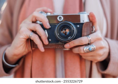 girl holding camera while walking. fashion and style. hipster girl takes pictures with a film camera. lifestyle concept, focus on camera. - Powered by Shutterstock