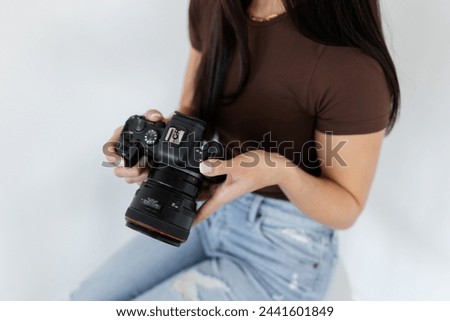 A girl holding a Canon camera, partial view