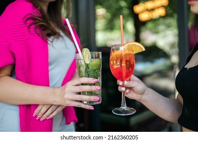 Girl Holding Cocktails In Her Hands Girl Holding Aperol And Mojito In Her Hands. Summer Time. Heat.